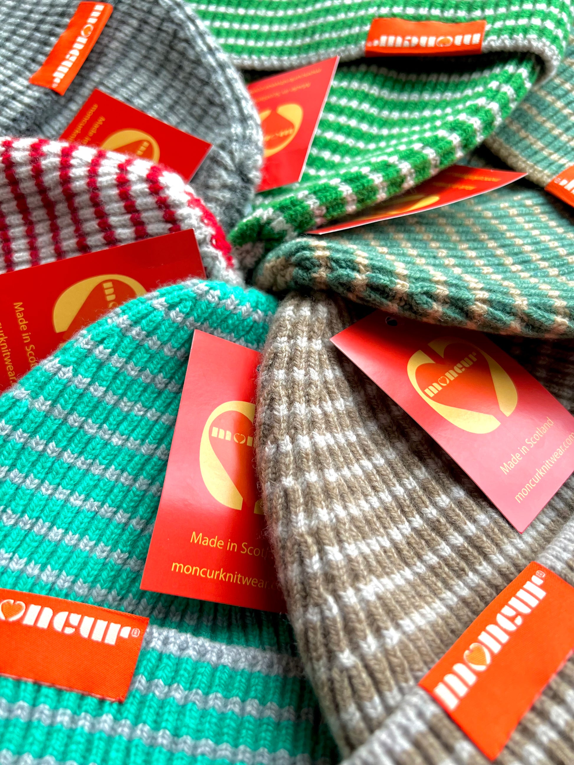 close up detail of fully fashioned ribbed striped hats in selection of colours made in Scotland by moncur knitwear
