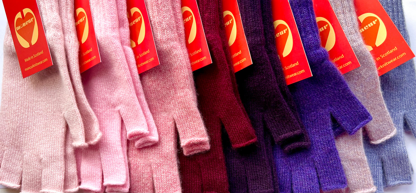 display of pink and purple shades of moncur cashmere gloves all neatly lined up in shade order from lightest pink through darker shades to light purples