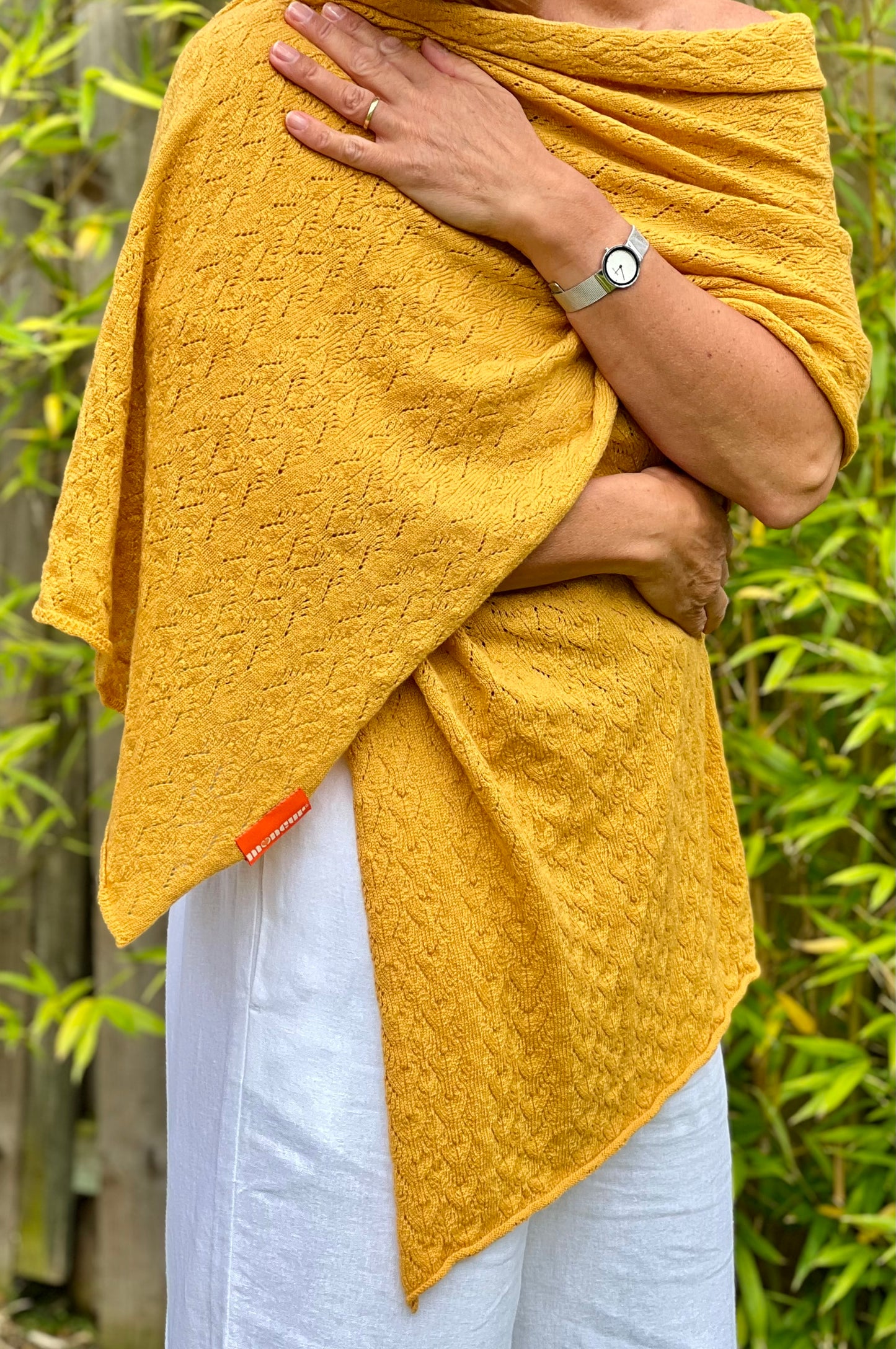 golden lace wrap pattern detail moncur knitwear wrapped around the body to show width and length of lacey shawl