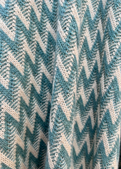 close up detail of the green and beige natural colours in the zig zag wrap in cashmere
