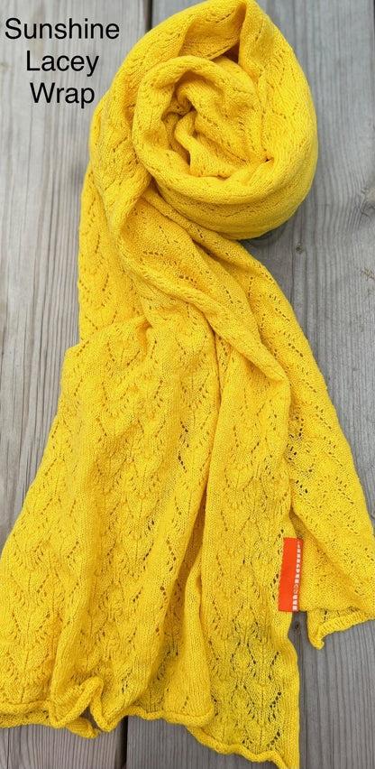 sunshine lace wrap laid on wooden surface to show delicate pattern of the cashmere